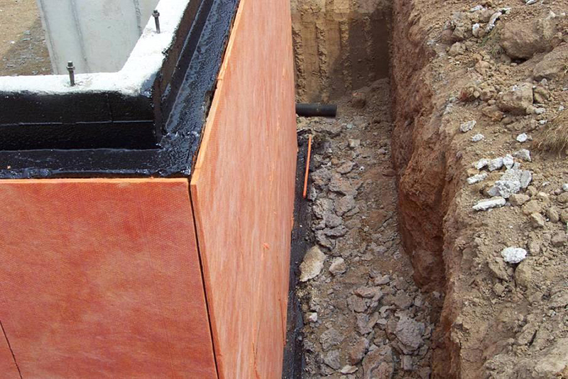 Монтаж теплоизоляционных пенополистироловых плит на фундамент здания.