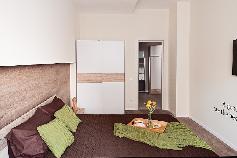 Изголовье кровати выполнено из "прыгнувшего" на стену ламината